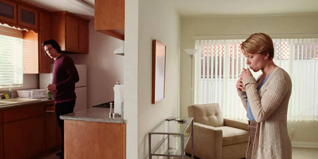 Duas pessoas de pé, separadas por uma parede.