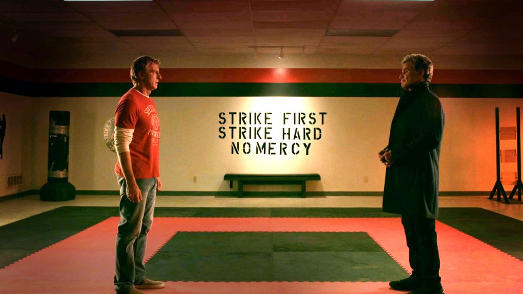 Dois homens se encarando em cena da série Cobra Kai