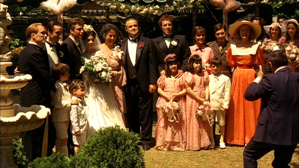 Uma família se reunindo para tirar foto, em uma festa de casamento