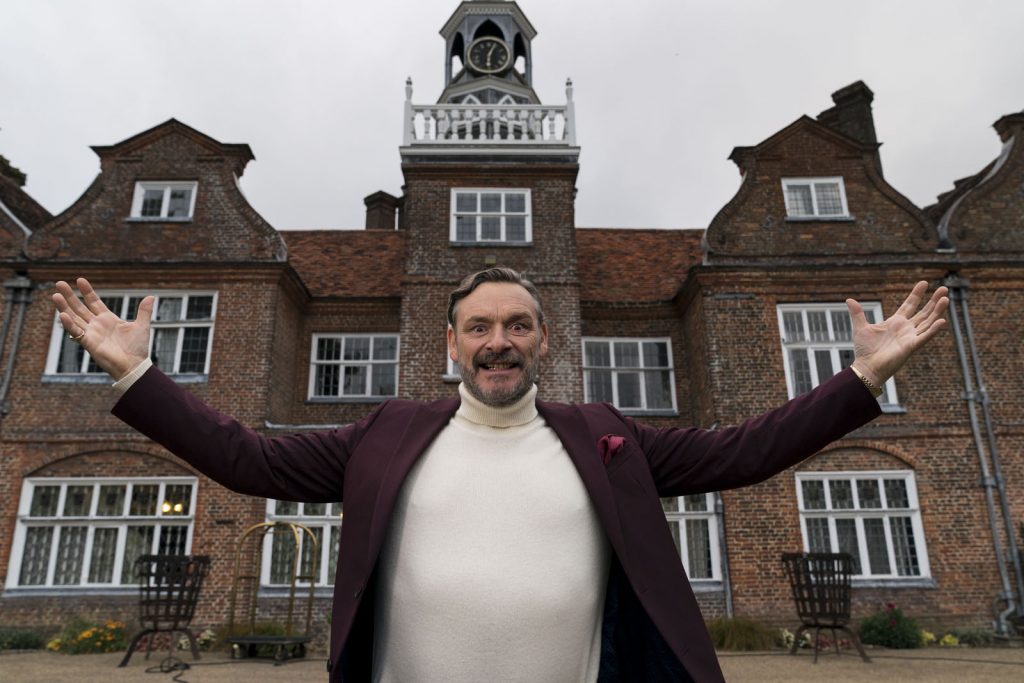 Julian Barratt, caracterizado com o Dr. Peter Toynbee, na frente de uma antiga mansão inglesa que serve de um dos cenário para série