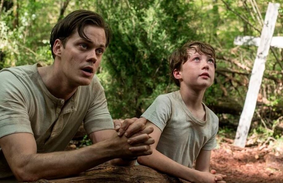 Willard Russell (Bill Skarsgård) rezando com seu filho