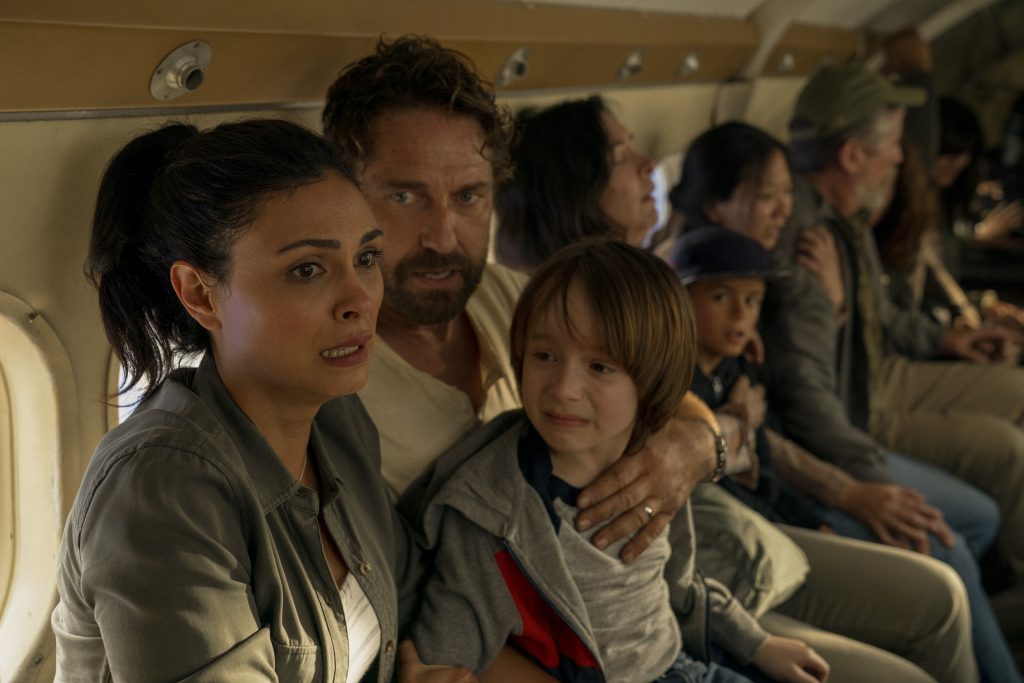 Morena Baccarin e Gerard Butler em um avião em cena do filme Destruição Final: O Último Refúgio