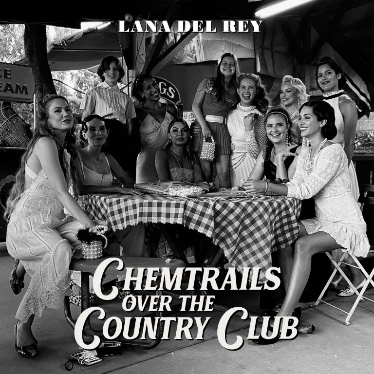 A cantora Lana Del Rey em pé em frente a uma mesa com suas amigas sentadas na capa do album Chemtrails Over The Country Club. Otageek