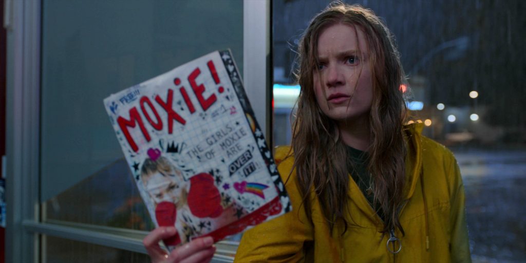 Garota na chuva com um caderno na mão no filme MOXIE: QUANDO AS GAROTAS VÃO À LUTA, na Netflix 