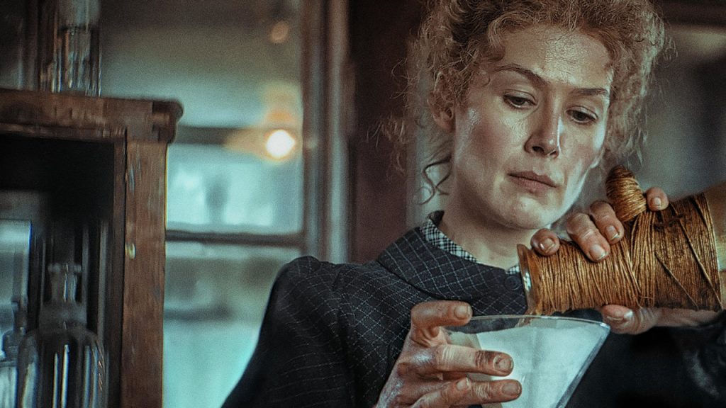 Cena de uma mulher ruiva observando uma taça enquanto a enche com uma garrafa - Otageek