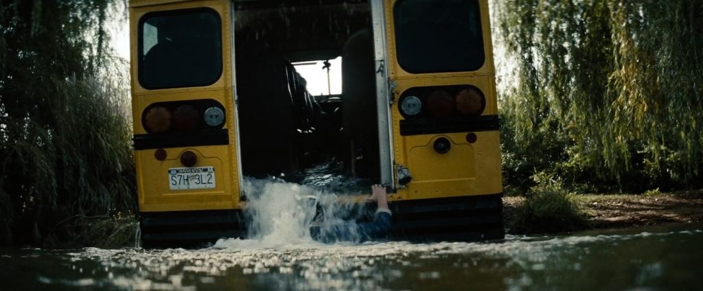 Clark Kent, menino, tira um ônibus escolar do rio.