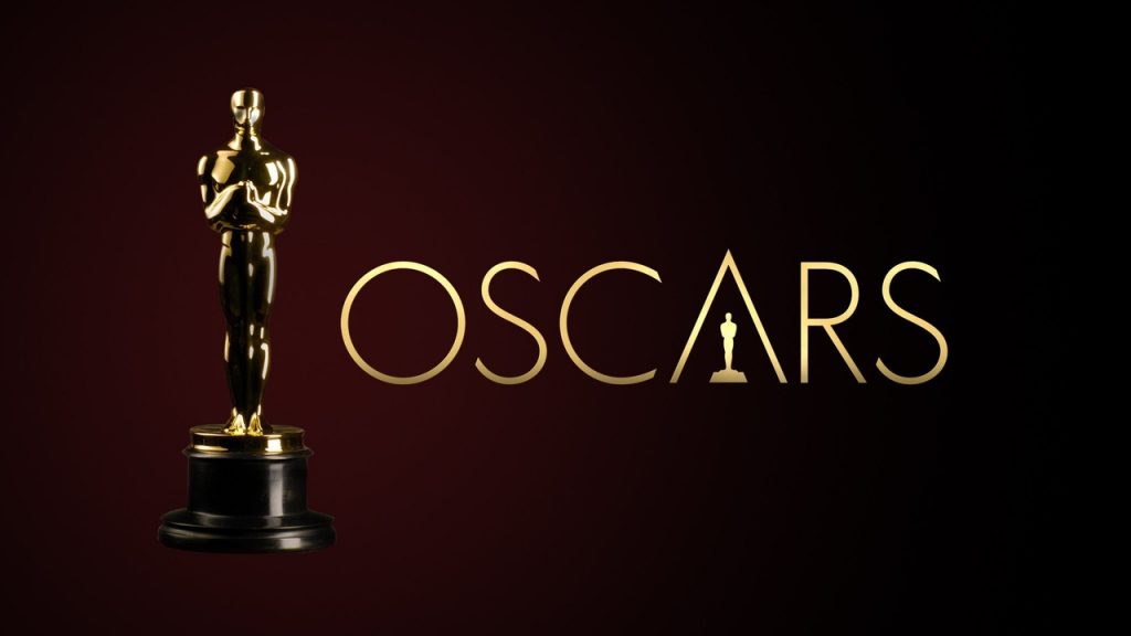Imagem promocional da premiação anual dos Oscars. Nela, à esquerda, vemos a tradicional estatueta da premiação e, ao seu lado, um logo escrito "OSCARS" ocupa o resto da imagem. Tanto a estatueta quanto o logo são dourados, e estão de frente a um fundo vermelho.