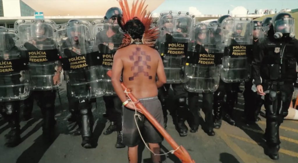 Indígena recua ante o avanço da tropa de choque da Polícia Federal em um protesto no documentário O Despertar da Florestania .