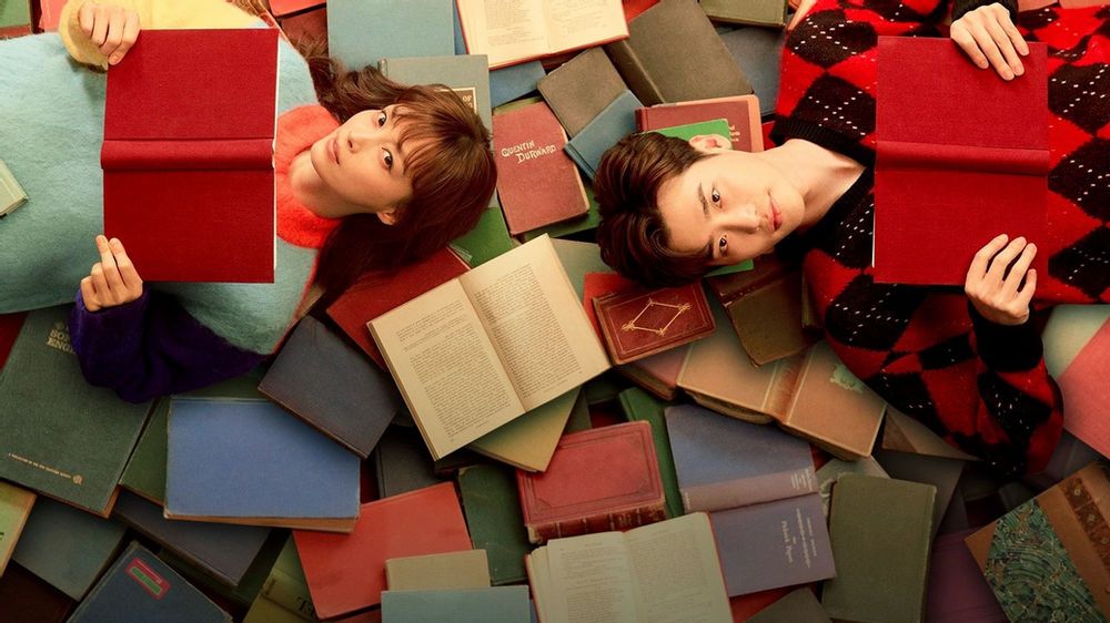 Protagonistas do romance deitados em cima de vários livros
