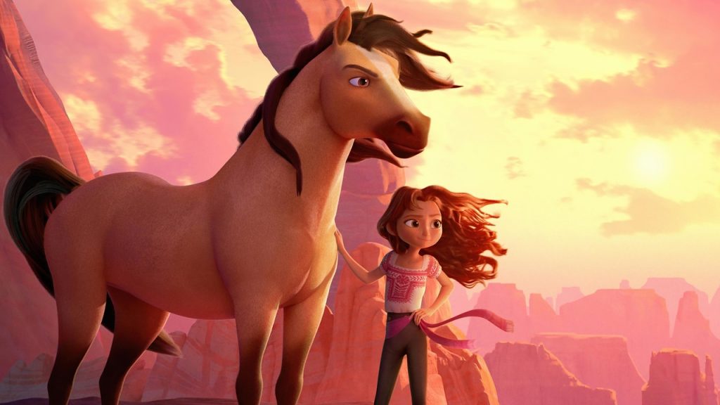 Imagem promocional do filme Spirit: O Indomável (2021). Nela, vemos o personagem-título, o cavalo Spirit, de corpo caramelo e crina e rabo marrons, sob o pôr do sol, ao lado de sua companheira de aventura, a adolescente Lucky Prescott, uma menina com cabelos castanhos ao vento, vestindo uma camiseta branca e rosa.