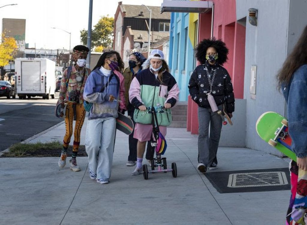 Personagens da série Betty andando na rua e conversando em um episódio.