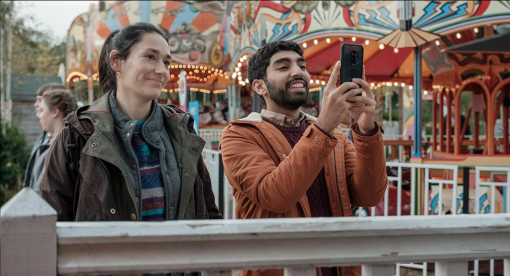 Sian Clifford e Mawaan Rizwan tirando foto com seu celular em cena de Two Weeks To Live