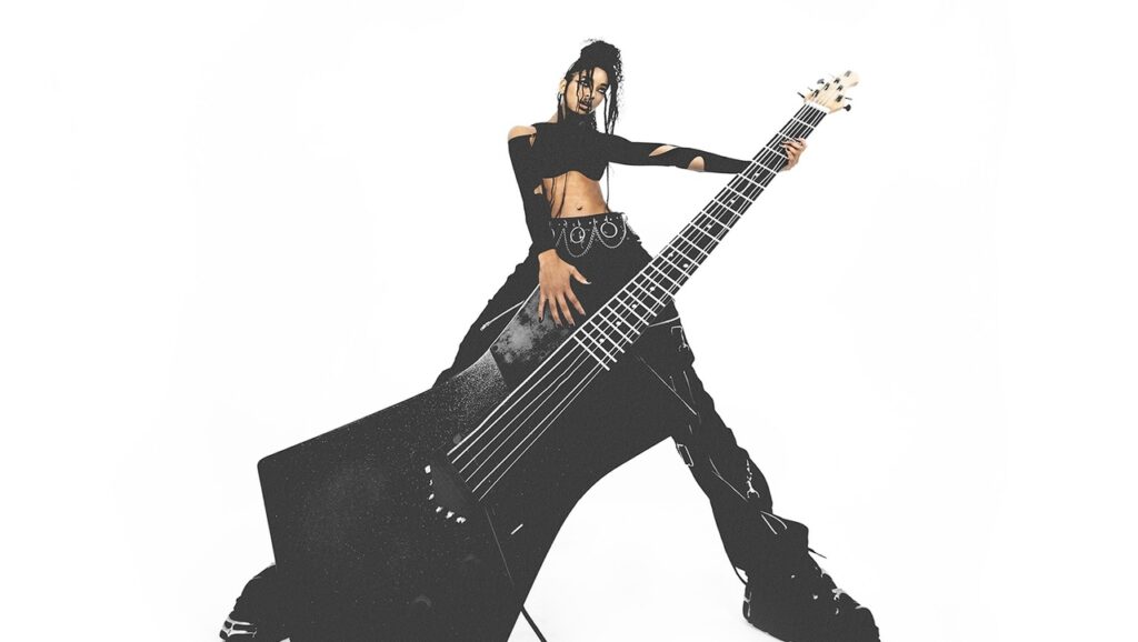 Imagem de Willow Smith. Nela, a cantora é fotografada de baixo para cima, em um ângulo  contra-plongée, com uma guitarra preta, que ocupa a maior parte da foto.