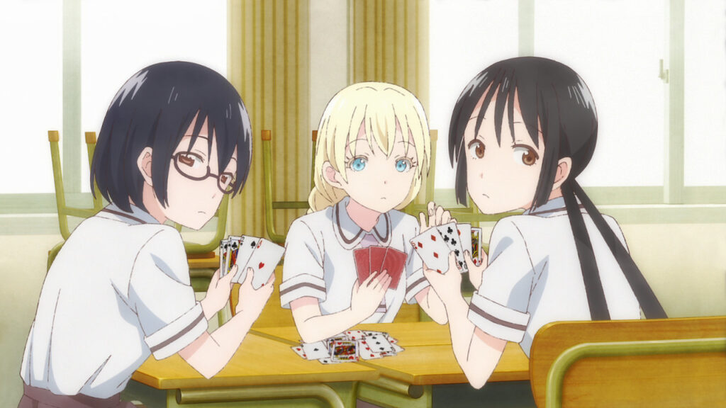 Personagens do anime Asobi Asobase jogando um jogo de baralho na escola.