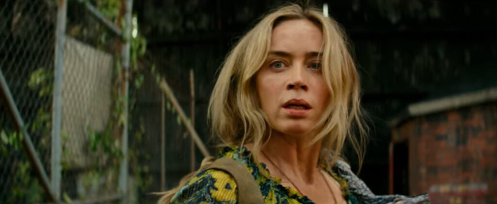 Imagem promocional do filme "Um Lugar Silencioso - Parte II". Nela, podemos ver Evelyn, a personagem de Emily Blunt, assustada, em um cenário abandonado.