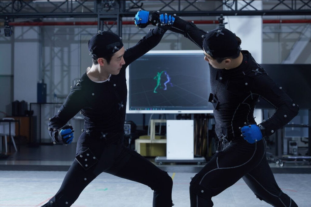 Imagem de dois atores realizando captura de movimentos, simulando uma briga, em um espaço similar ao que se imagina que será o Pearl Abyss Art Center