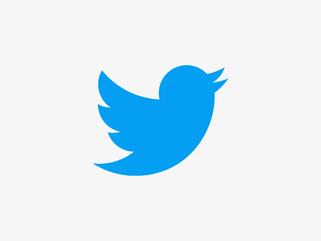 Ilustrando a notícia do Dia Mundial do Emoji, temos o logo do Twitter: a silhueta de um um passarinho azul em um fundo branco.