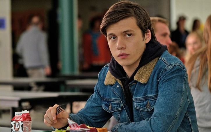 Imagem do filme "Com Amor, Simon" que mostra o personagem principal, Simon, sentado na cafeteria da escola 