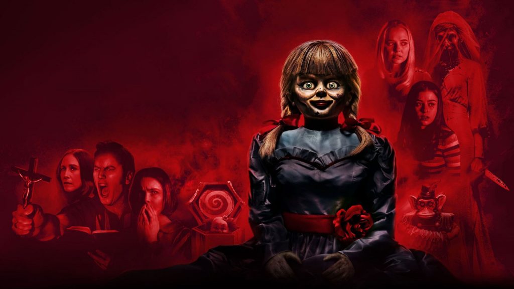 Poster oficial de 'Anabelle 3' onde mostra a boneca Anabelle com os outros personagens do filme ao fundo da imagem  