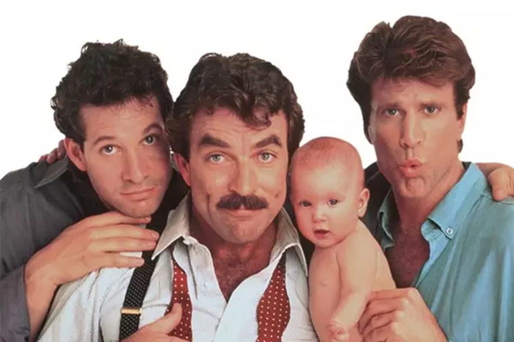 Na imagem, os três pais Peter, Michael e Jack, do filme "Três Solteirões e um Bebê", com a bebê do título do lado de Michael.