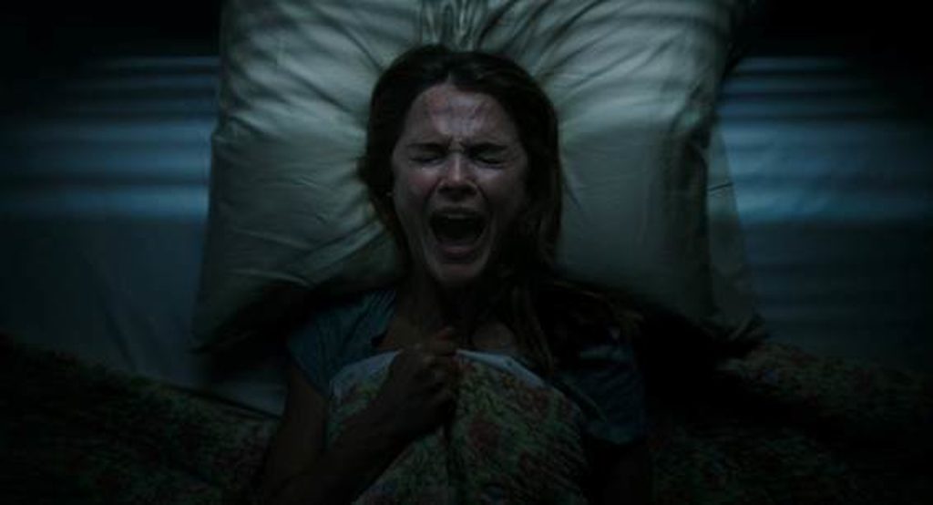Rebecca Hall chora em desespero deitada na cama no escuro em foto do filme "Espíritos Obscuros"  da Searchlight Pictures