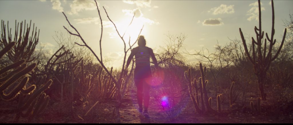 Imagem promocional da série "Cangaço novo", onde vemos uma garota correndo no sertão do Nordeste brasileiro em direção ao sol