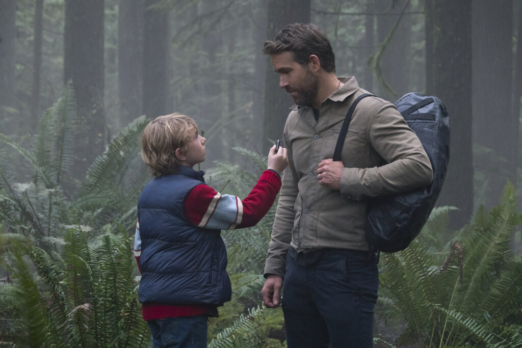 Na foto, Walker Scobell que interpreta o jovem Adam e Ryan Reynolds que faz o já crescido Adam.