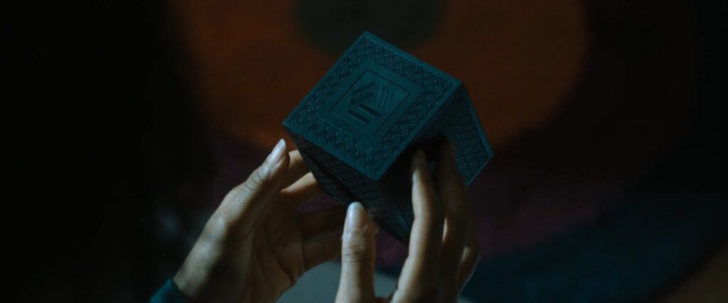 Uma personagem manipula um cubo em Escape Room