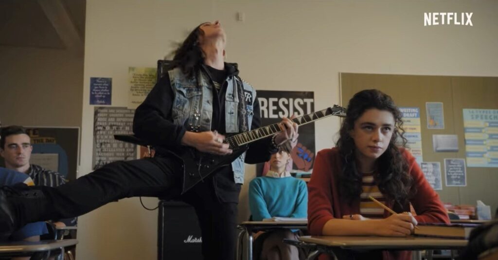 Kevin tocando guitarra na sala de aula 