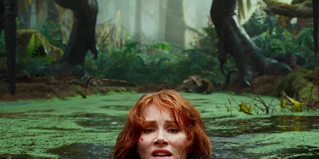 A atriz Bryce Dallas nadando em um lago esverdeado com um dinossauro logo atrás.