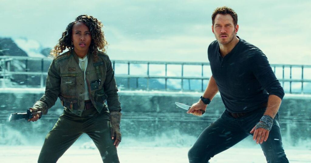 A atriz DeWanda Wise e o ator Chris Pratt segurando facas a armas de choque para se defenderem de dinossauros. 