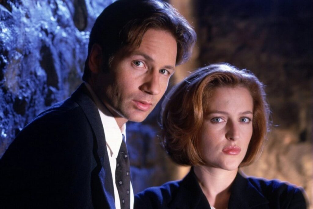Foz Mulder e Dana Scully olham para nós na tradicional quebra da 4ª parede, comum em pôsters.