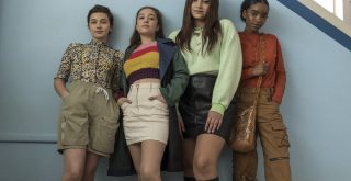 Grupo diverso de meninas encostado em uma parede azul